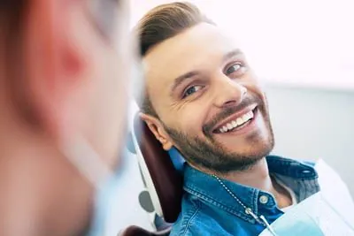 man smiling during his dental appointment at Ember Dental Arts