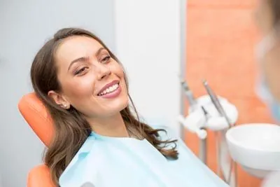 woman smiling after her oral surgery procedure at Ember Dental Arts